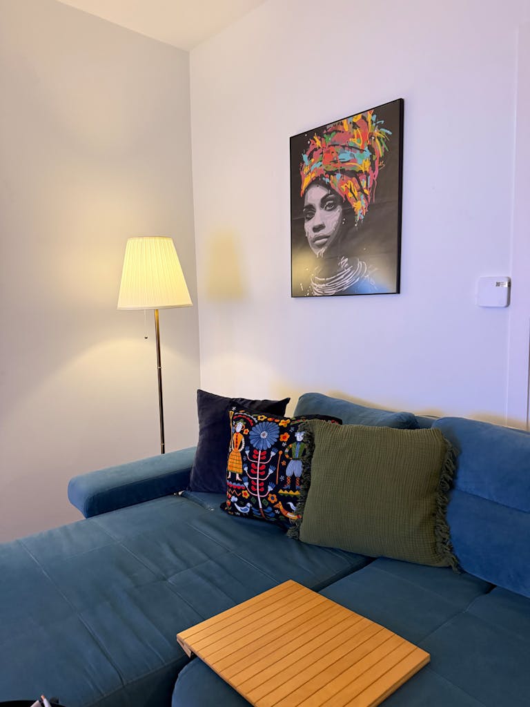 Inviting living room with lamp, sofa, and unique wall art. Perfect for relaxation.